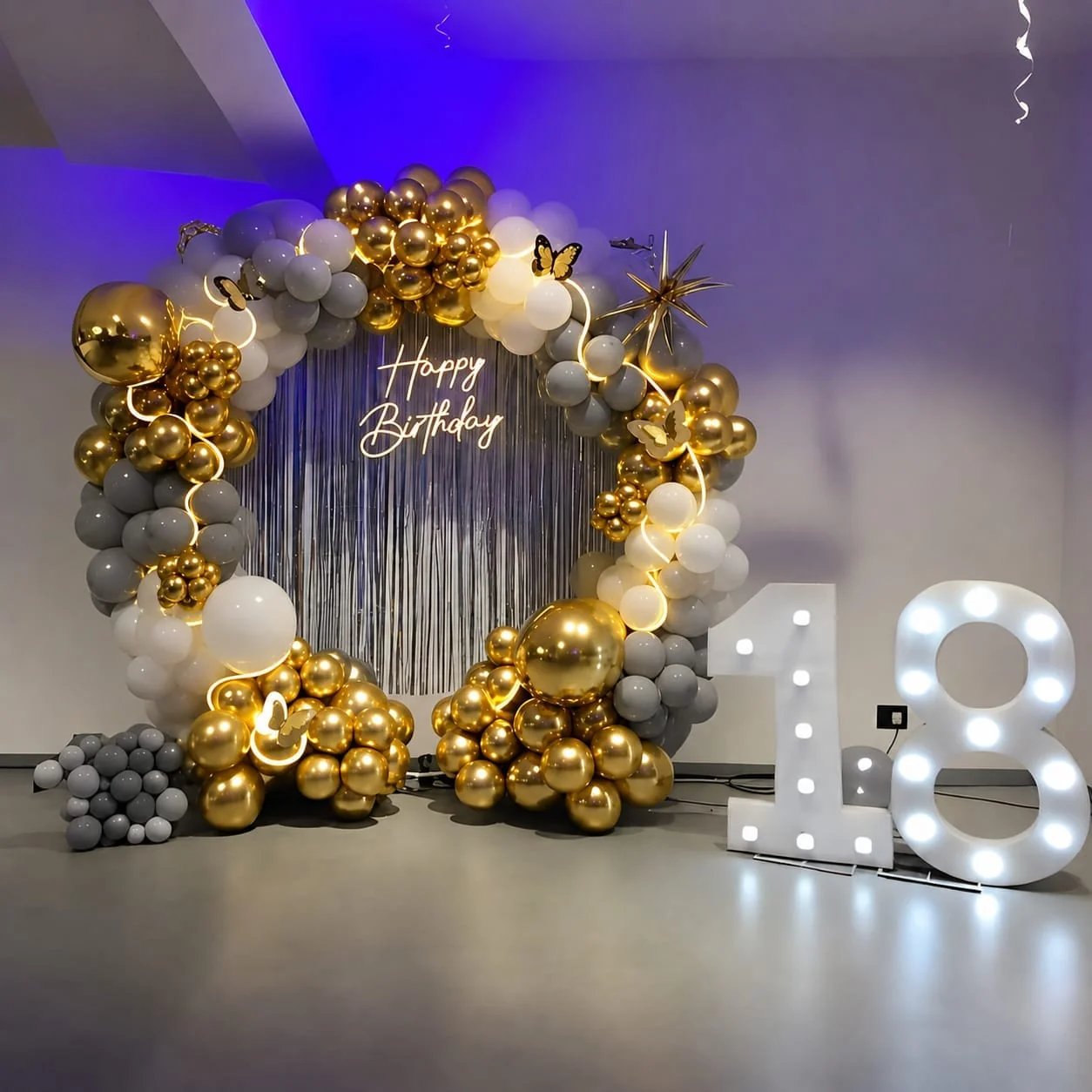 Gold, grey and white balloon ring with a neon Happy Birthday sign and lit 18 numerals