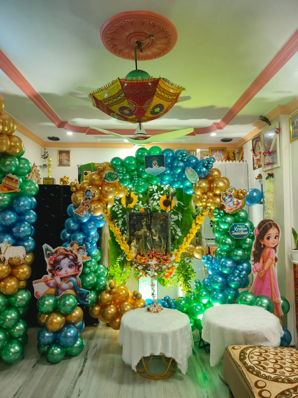 Emerald, teal and gold chrome balloon columns around a marigold-garland frame